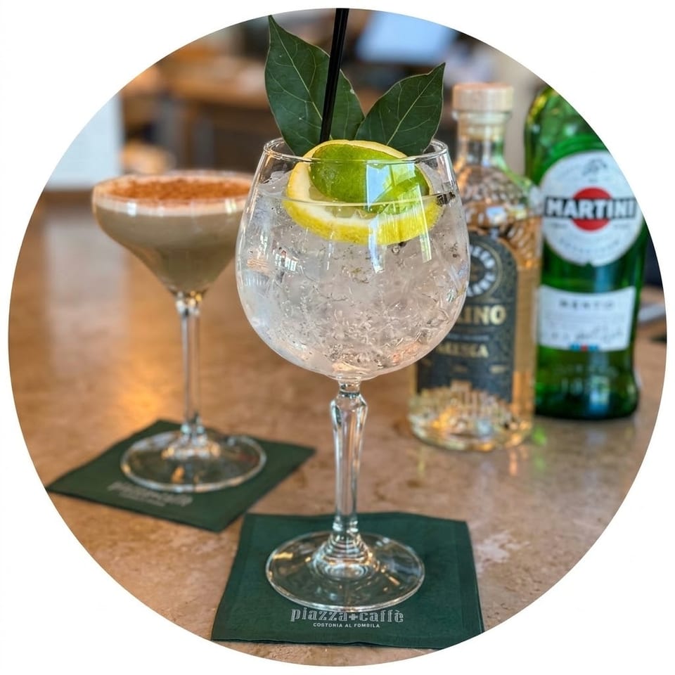 Gin and tonic garnished with lime and lemon in a balloon glass, with an espresso martini and Martini bottle behind it.
